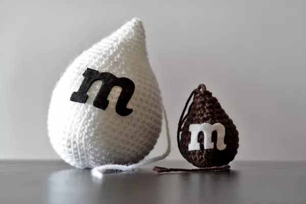 Pareja de logos de Metadrop hechos en lana sobre mesa.